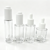 30ml clear glass serum bottles with white dropper caps in four different heights and designs for cosmetic packaging.