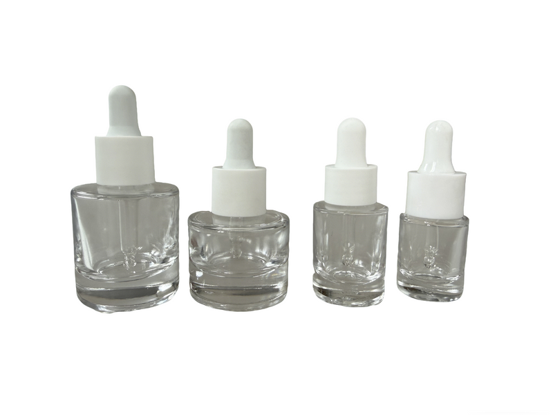 Four sizes of premium clear glass dropper bottles (5ml, 10ml, 20ml, 30ml) featuring a distinct round heavy thick-base design for luxury skincare products.